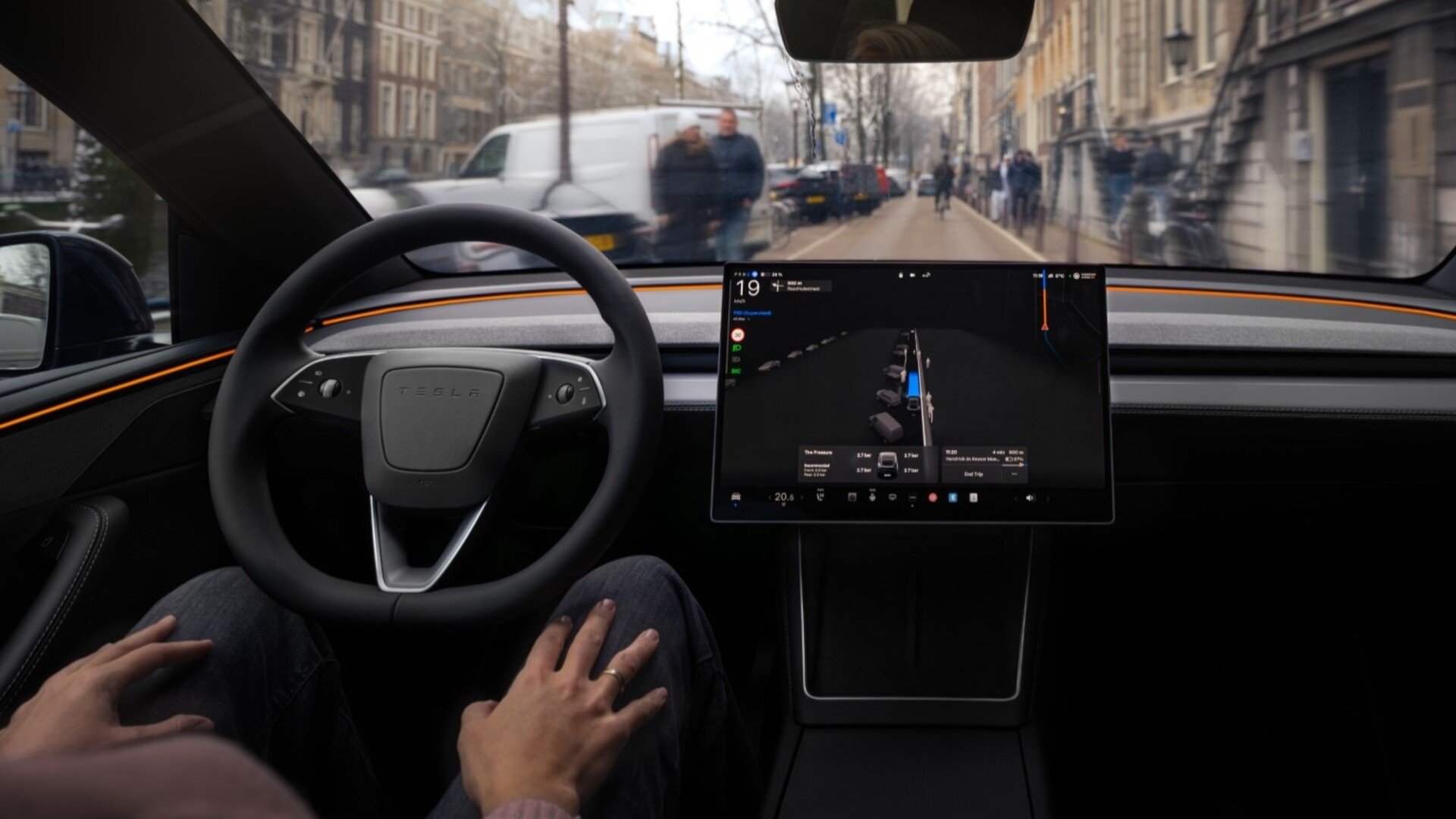À bord d'une Tesla, le FSD Supervised gère la conduite en ville pendant que le conducteur garde les mains sur les genoux